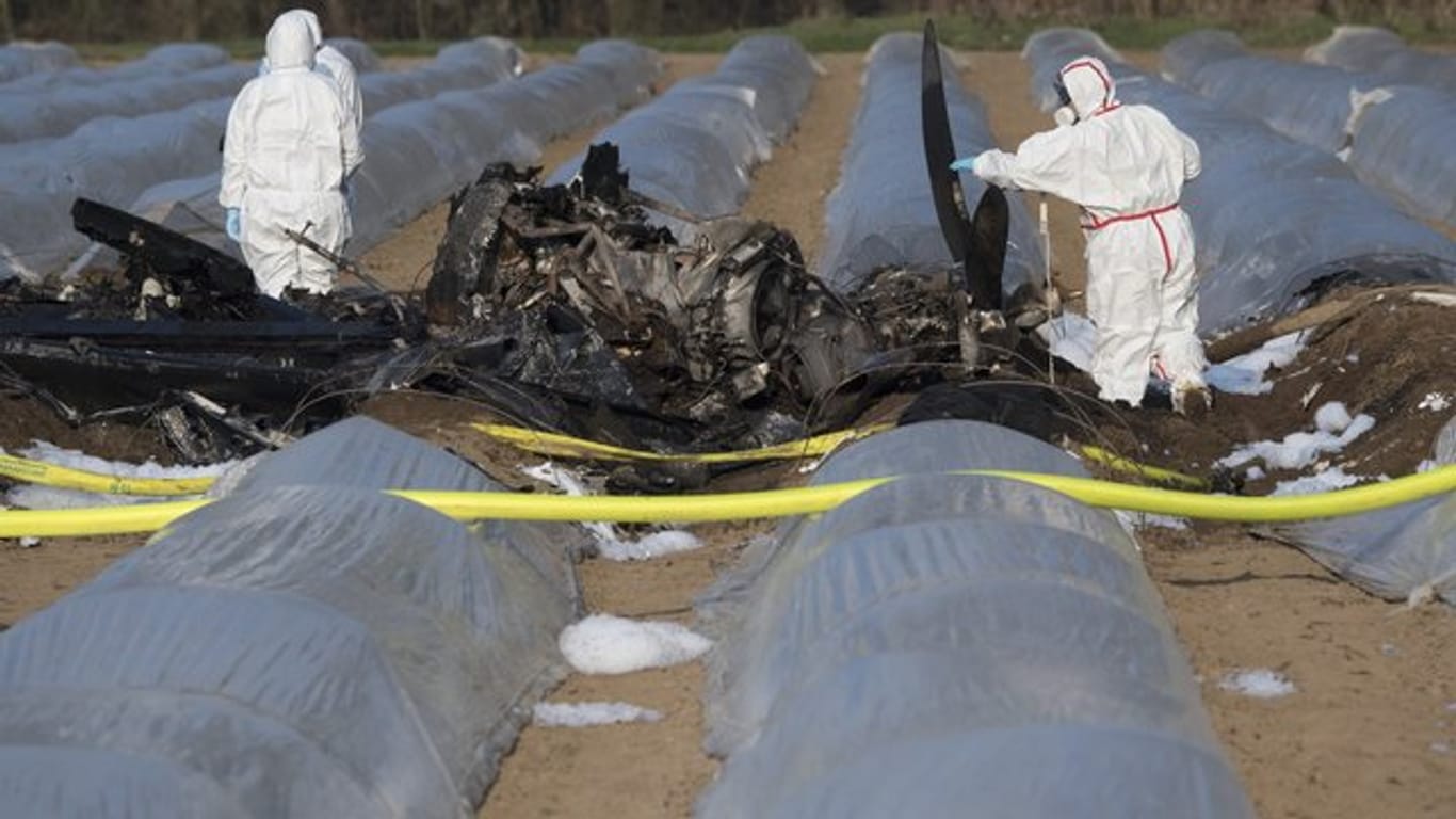 Beamte der Kriminalpolizei und Luftfahrtexperten untersuchen das Wrack eines am Vortag abgestürzten Geschäftsflugzeuges in der Nähe des Flugplatzes Egelsbach.