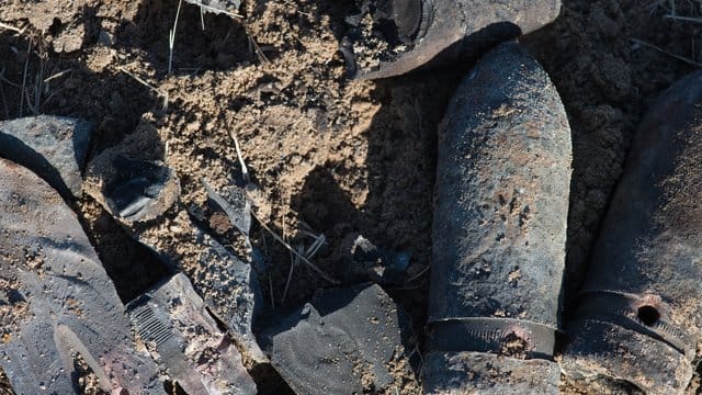 Granatsplitter und der ausgebrannte Granaten liegen auf einem Feld in Schönhausen, Sachsen-Anhalt.