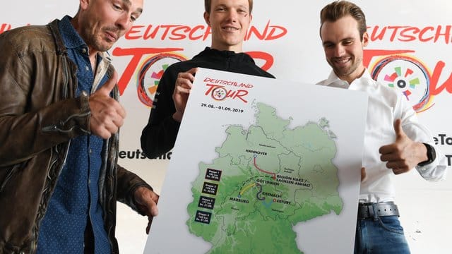 Die Radprofis John Degenkolb (l-r), Nikias Arndt und Maximilian Schachmann zeigen eine Karte mit den Stationen der diesjährigen Deutschland-Tour.