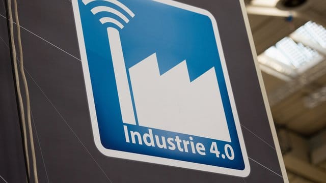Über einem Stand auf der Hannover Messe ist ein Piktogramm mit der Aufschrift "Industrie 4. Über einem Stand auf der Hannover Messe ist ein Piktogramm mit der Aufschrift "Industrie 4.