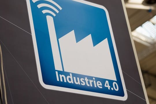 Über einem Stand auf der Hannover Messe ist ein Piktogramm mit der Aufschrift "Industrie 4.