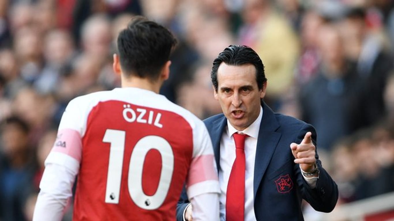 Arsenal-Trainer Unai Emery (r) gibt während eines Spiels Mesut Özil Anweisungen.