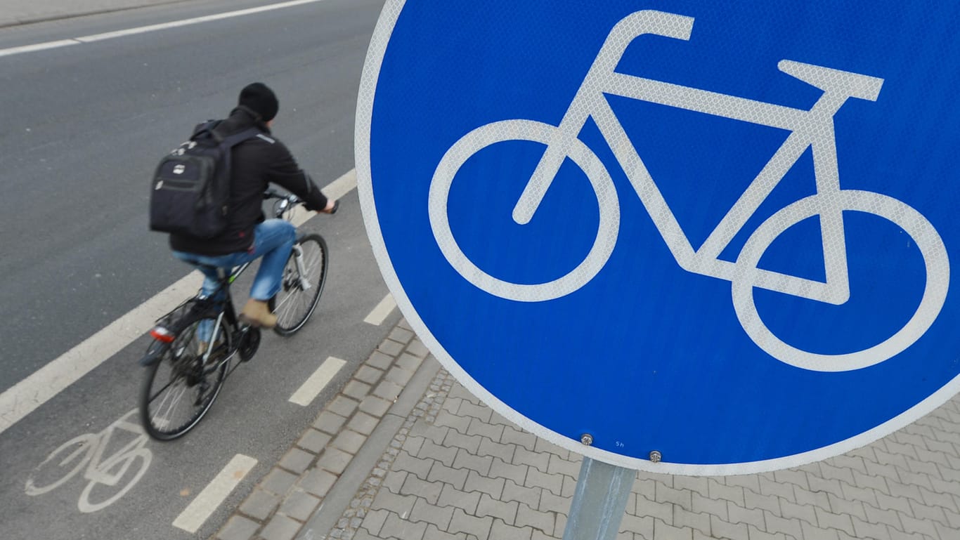 Fahrradfahrer auf Radweg: An dem blau-weißen Schild sind offizielle Wege für Radfahrer zu erkennen.