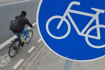 Fahrradfahrer auf Radweg: An dem blau-weißen Schild sind offizielle Wege für Radfahrer zu erkennen.