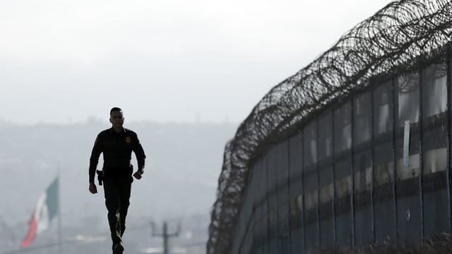 Ein Soldat läuft an der Grenze zwischen den USA und Mexiko entlang. Ein Soldat läuft an der Grenze zwischen den USA und Mexiko entlang.