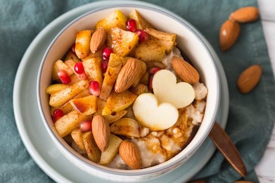 Bratapfel-Porridge: Kurz bevor der Brei fertig ist, wird ein Apfel hinzu geraspelt und mit viel Zimt und gehackten Nüssen abgerundet.