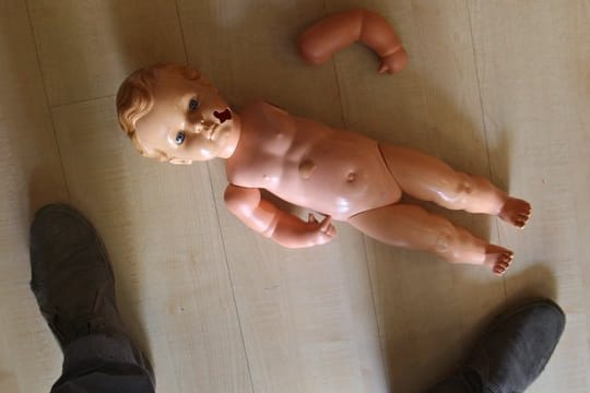 Beschädigte Kinderpuppe.