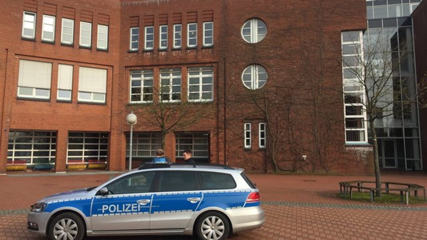 Ein Einsatzfahrzeug der Polizei steht während des Einsatzes vor der Eckener Schule in Flensburg.