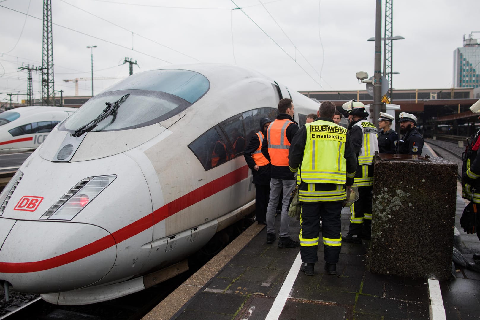 Düsseldorf: Einsatzkräfte von Polizei und Feuerwehr stehen neben einem ICE, bei dem das Drehgestell des hinteren Zugteils rauchte.