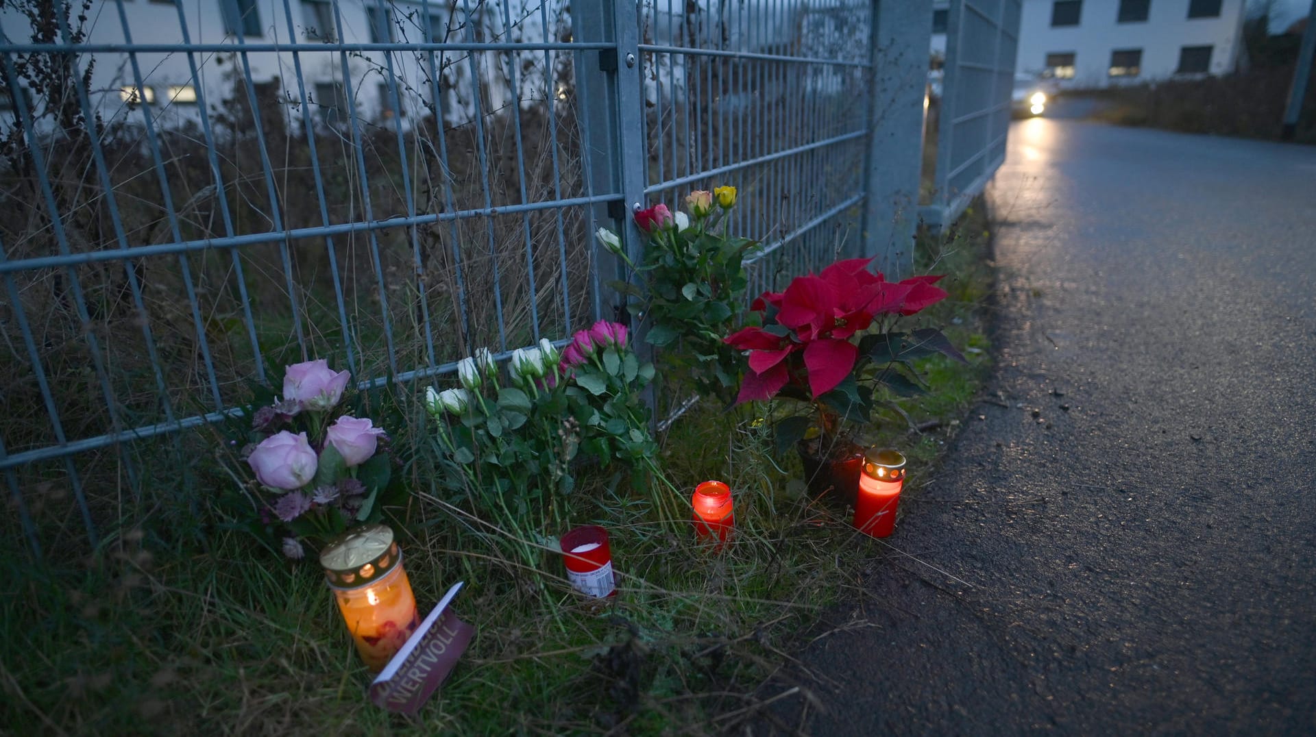 Blumen und Kerzen stehen am Eingang zu einer kommunalen Unterkunft, in der die Leiche der 17-Jährigen gefunden wurde. Blumen und Kerzen stehen am Eingang zu einer kommunalen Unterkunft, in der die Leiche der 17-Jährigen gefunden wurde.