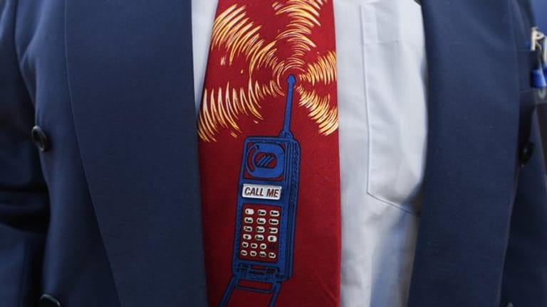 Ein Bieter trägt beim Start der Auktion von 5G-Mobilfunkfrequenzblöcken am Mainzer Technik-Standort der Bundesnetzagentur eine Krawatte mit einem Mobiltelefon.