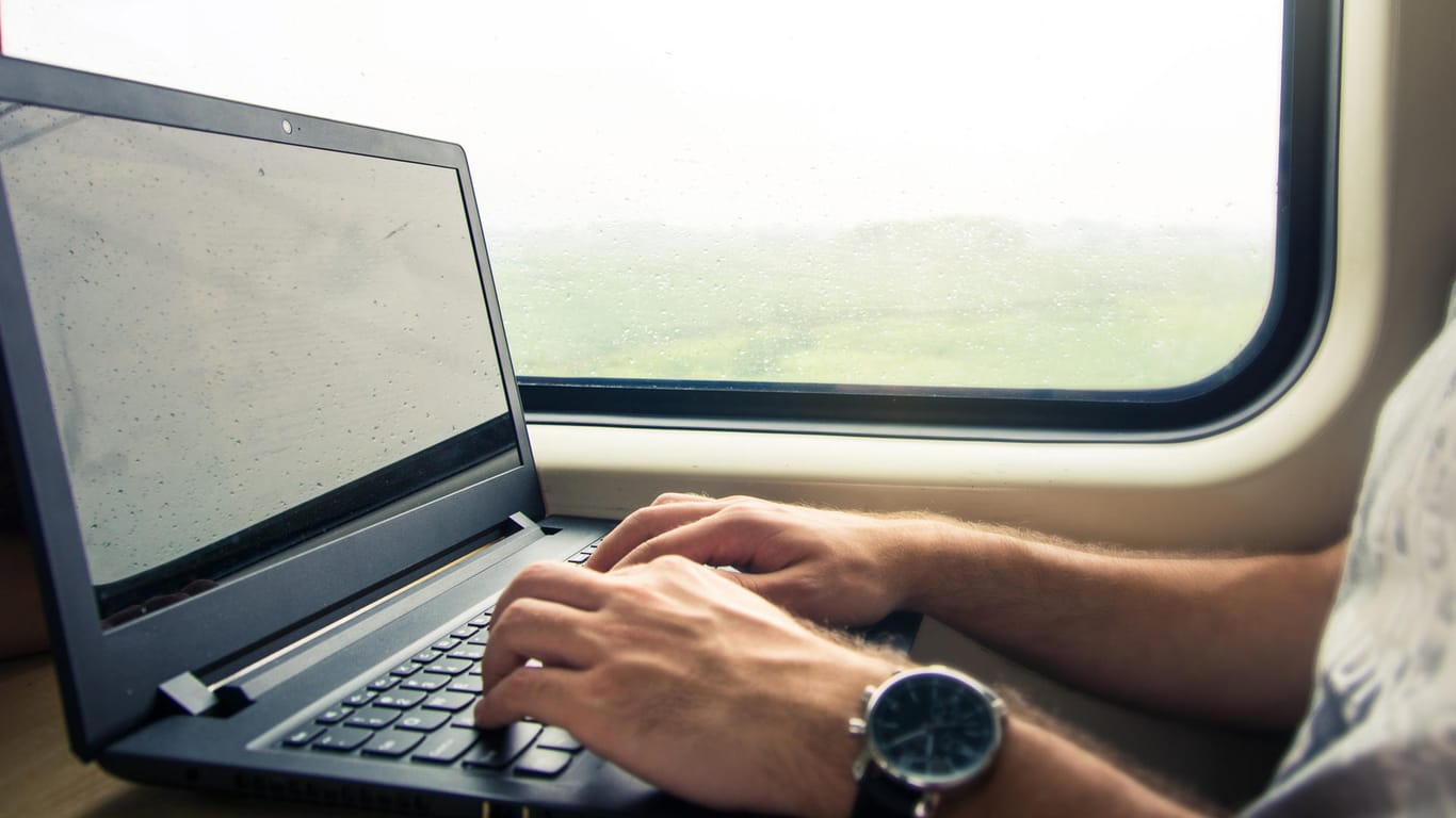 Ein Mann im Zug arbeitet an einem Laptop: Windows 10 bietet viele Möglichkeiten, das System nach eigenen Bedürfnisse zu optimieren.