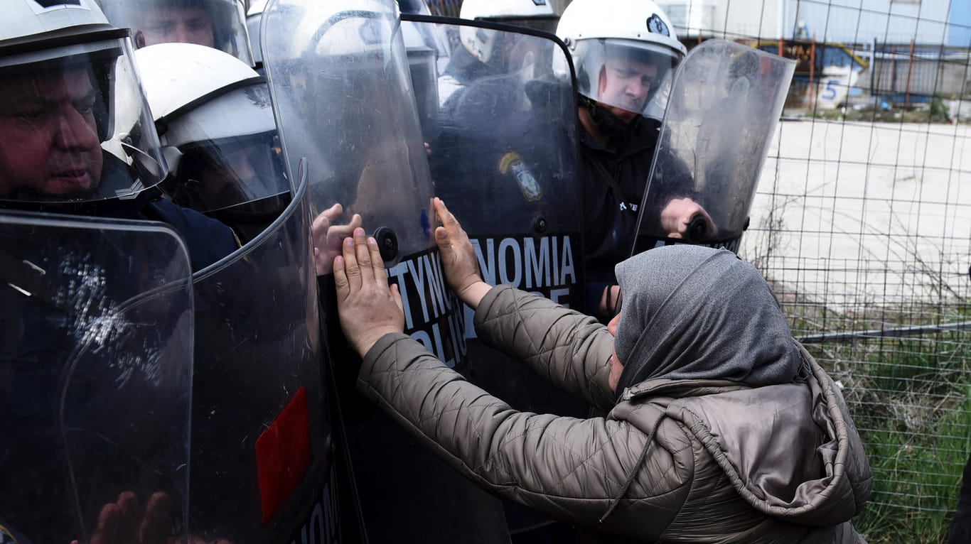 Eine Frau und Polizisten der Bereitschaftspolizei stoßen vor einem Flüchtlingslager westlich von Thessaloniki aufeinander: Hunderte Migranten haben versucht, Polizeisperren zu durchbrechen.