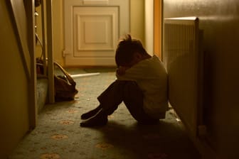 Ein Junge sitzt im Flur: Sexueller Kindesmissbrauch hat für die Opfer meist lebenslange Folgen.