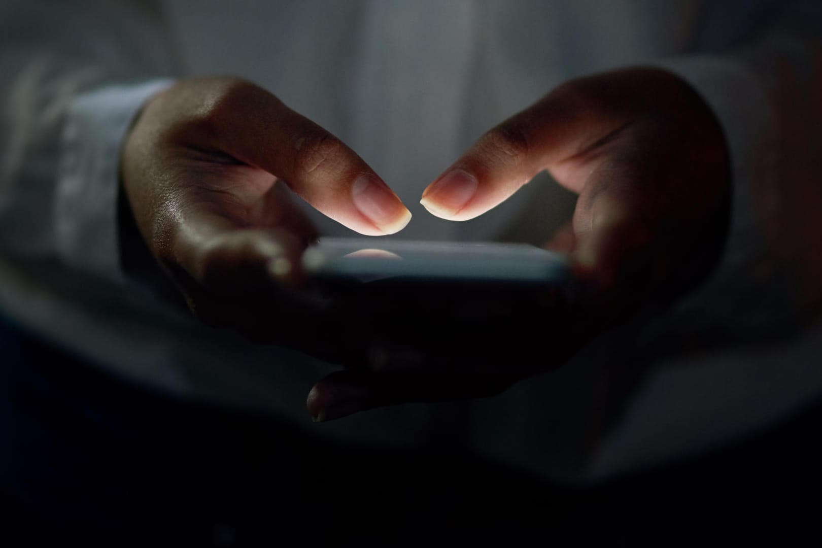 Eine Person tippt im Dunkeln auf dem Smartphone: Seit Anfang 2018 müssen soziale Netzwerke konsequent gegen Hasskommentare vorgehen.