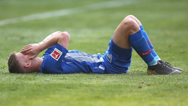 Hertha-Spieler Maximilian Mittelstädt liegt nach dem Abpfiff frustriert auf dem Spielfeld. Hertha-Spieler Maximilian Mittelstädt liegt nach dem Abpfiff frustriert auf dem Spielfeld.