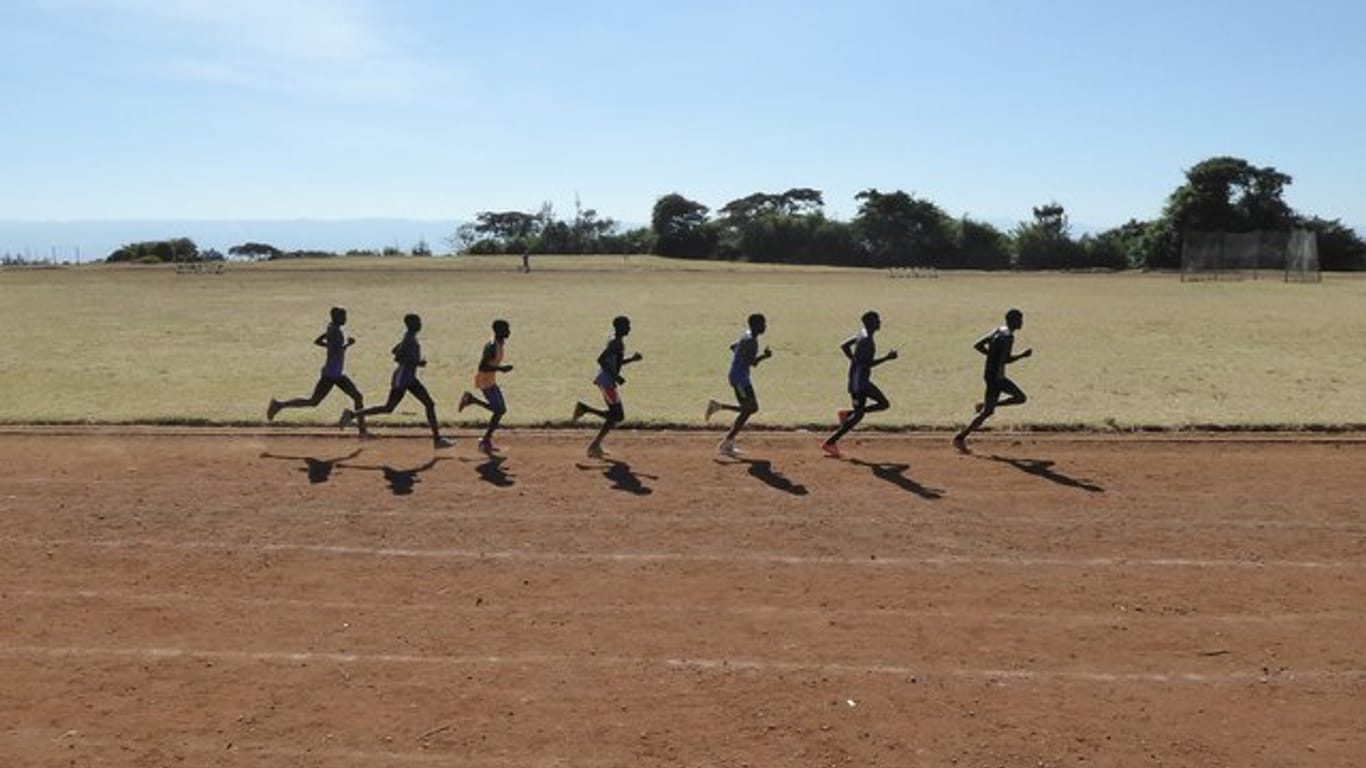 Eine Gruppe kenianischer Läufer zieht auf der Sandbahn des Sportplatzes in Iten ihre Runden.