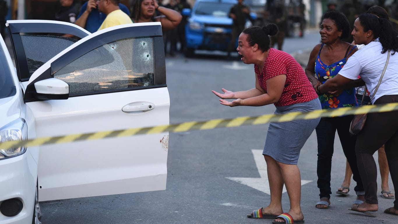 Fassungslosigkeit: Eine Angehörige weint beim Blick auf das zerschossene Auto der Familie.