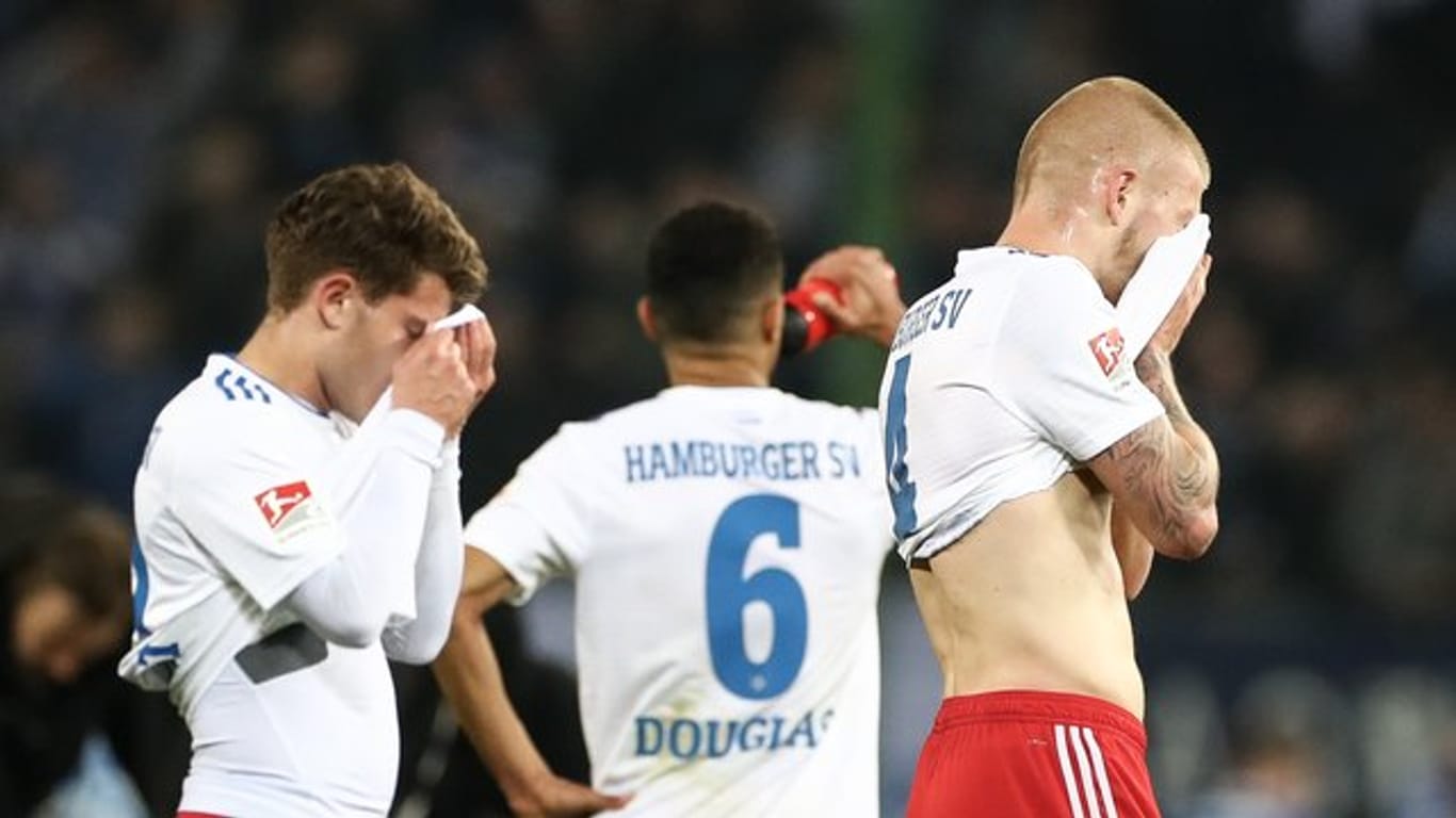 Mats Köhlert (l-r), Douglas Santos und Rick van Drongelen sind fassungslos: Der HSV hat daheim gegen Magdeburg mit 1:2 verloren.