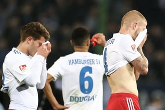 Mats Köhlert (l-r), Douglas Santos und Rick van Drongelen sind fassungslos: Der HSV hat daheim gegen Magdeburg mit 1:2 verloren.
