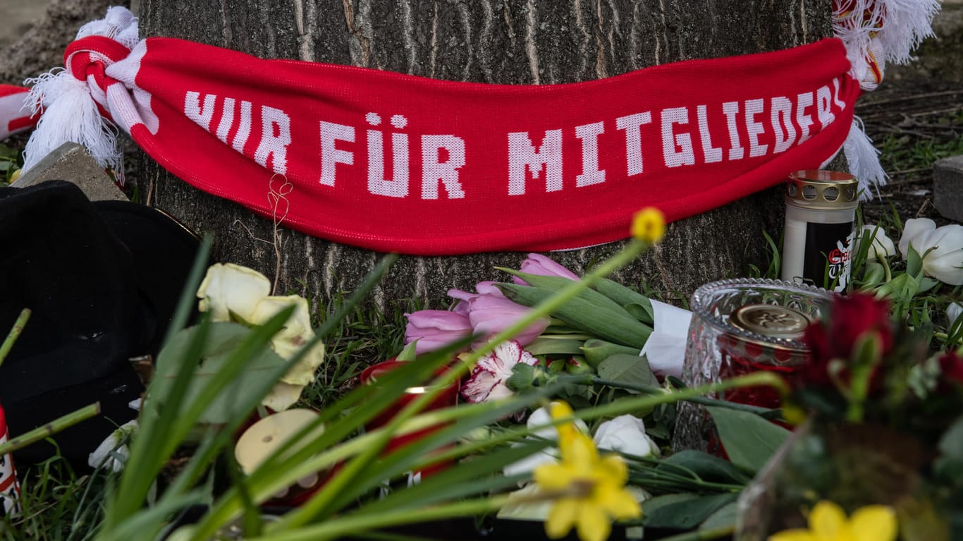 Berlin: Blumen und Kerzen sowie ein Fan-Schal vom FC Union haben Menschen auf einem Parkplatz an der Stahlheimer Straße abgelegt.