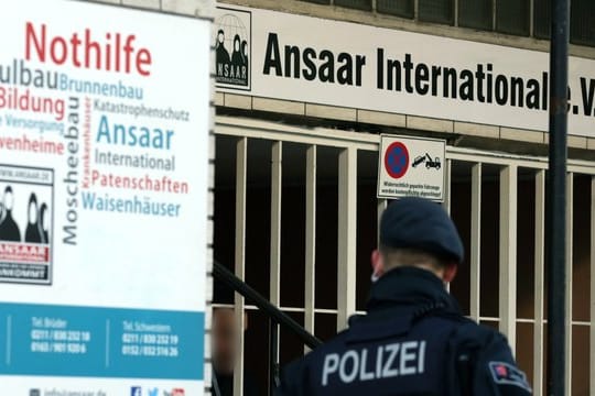 Polizeibeamte stehen vor dem Hauptsitz des Vereins Ansaar International in Düsseldorf.