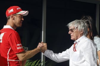 Bernie Ecclestone (r) begrüßt Sebastian Vettel 2017 beim Großen Preis von Bahrain im Fahrerlager.