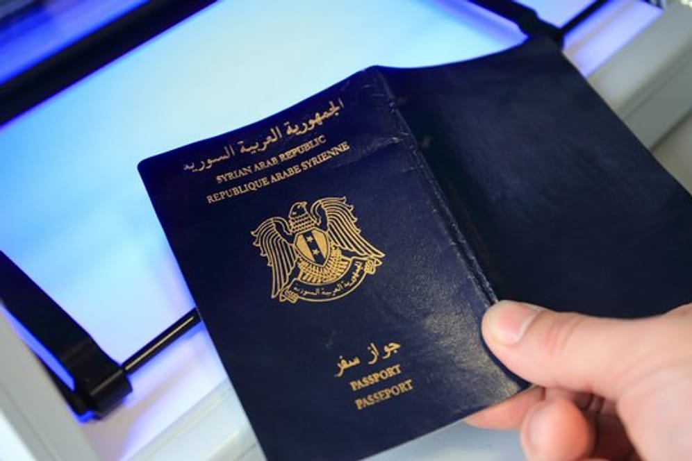 Ein syrischer Pass wird mit einem speziellen Gerät in einem Ankunftszentrum für Asylbewerber auf Echtheit geprüft.