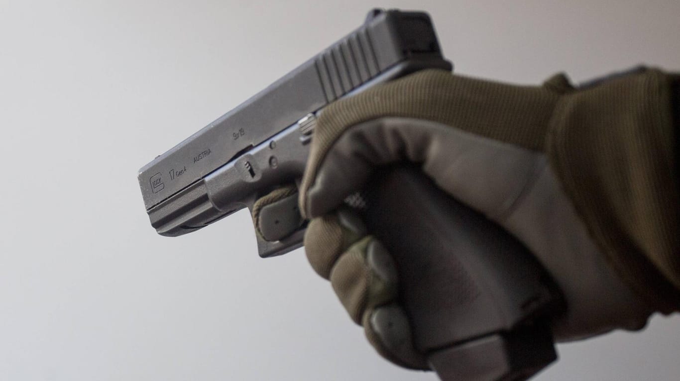 Eine Hand hält eine Pistole: Der Mann hatte sich zuvor in dem Geschäft nach Vogelfutter erkundigt, anschließend kam er mit einer Waffe zurück. (Symbolbild)