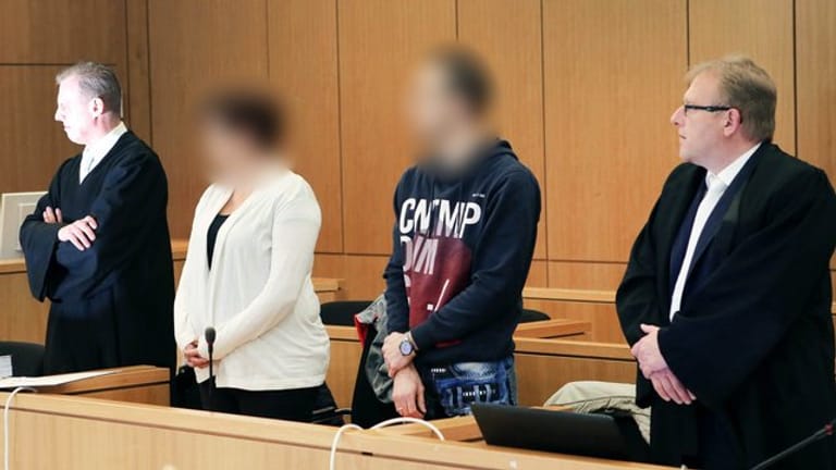 Mutter und Vater stehen zu Beginn des Prozesses im Gerichtssaal in Aachen.