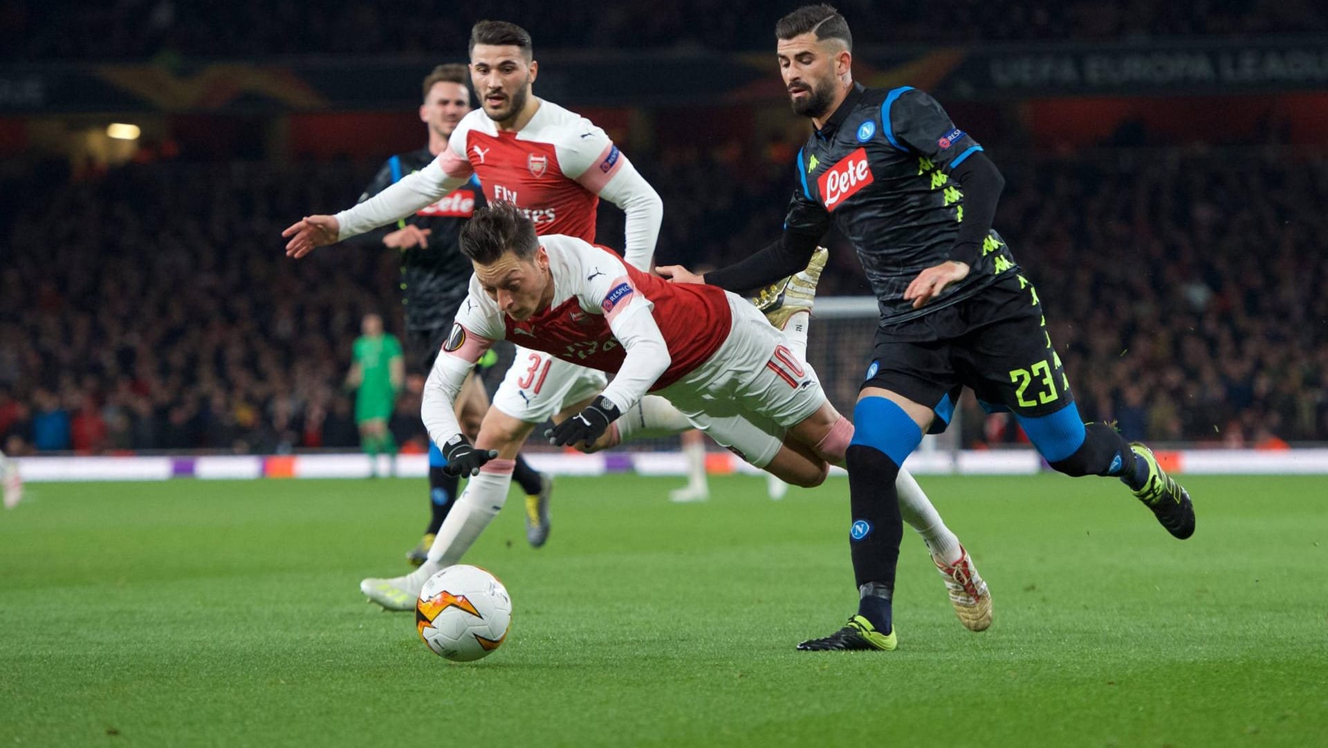 Arsenals Mesut Özil verliert im Duell gegen Neapels Hysaj (r.) das Gleichgewicht.