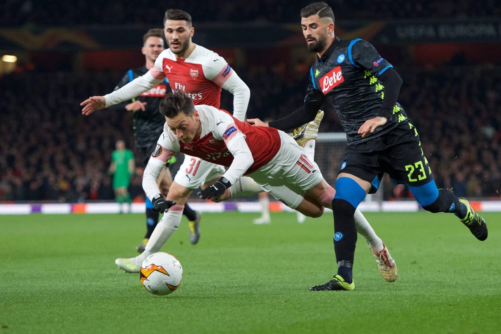 Arsenals Mesut Özil verliert im Duell gegen Neapels Hysaj (r.) das Gleichgewicht.