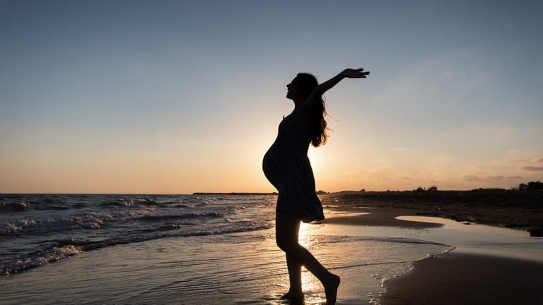 Schwangere am Strand: Viele werdende Eltern fahren noch einmal in den Urlaub, bevor das Baby da ist.