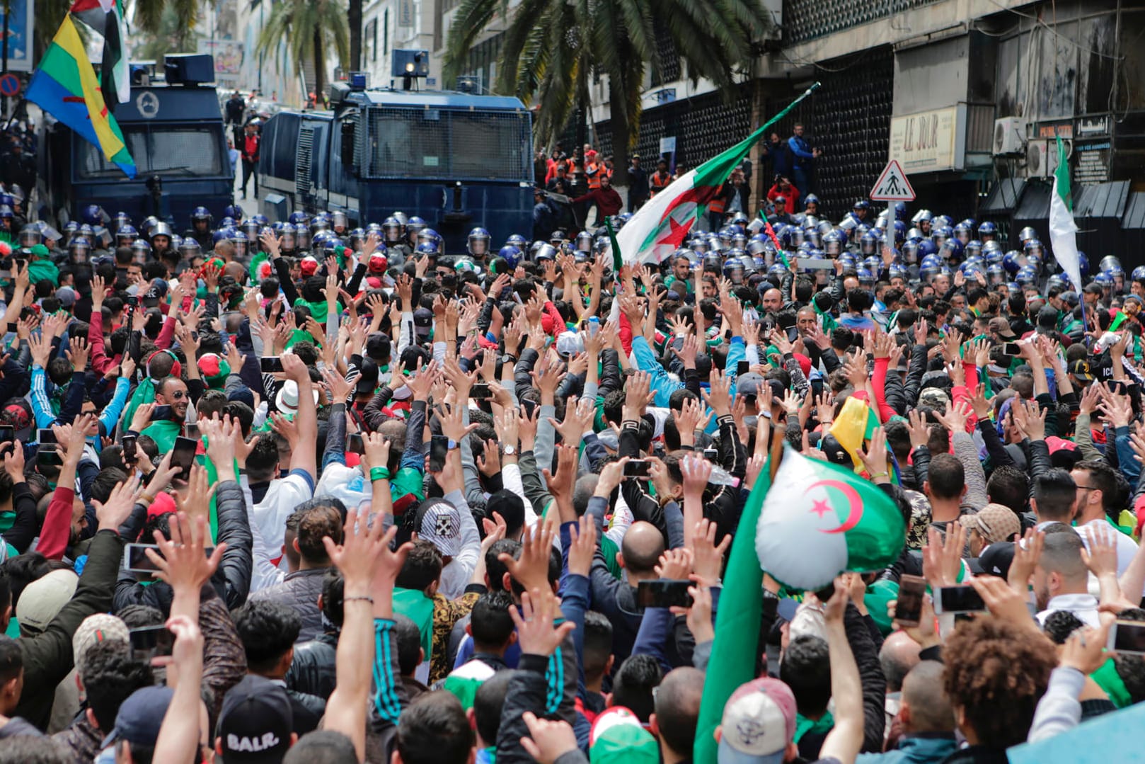 Algerische Demonstranten rufen vor Sicherheitskräften gegen die Regierung Slogans: Tausende von Algeriern strömten in die Hauptstadt, um die Abreise des neu ernannten Präsidenten Abdelkader Bensalah zu fordern.