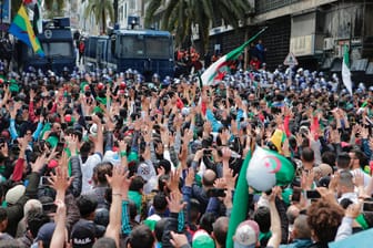 Algerische Demonstranten rufen vor Sicherheitskräften gegen die Regierung Slogans: Tausende von Algeriern strömten in die Hauptstadt, um die Abreise des neu ernannten Präsidenten Abdelkader Bensalah zu fordern.
