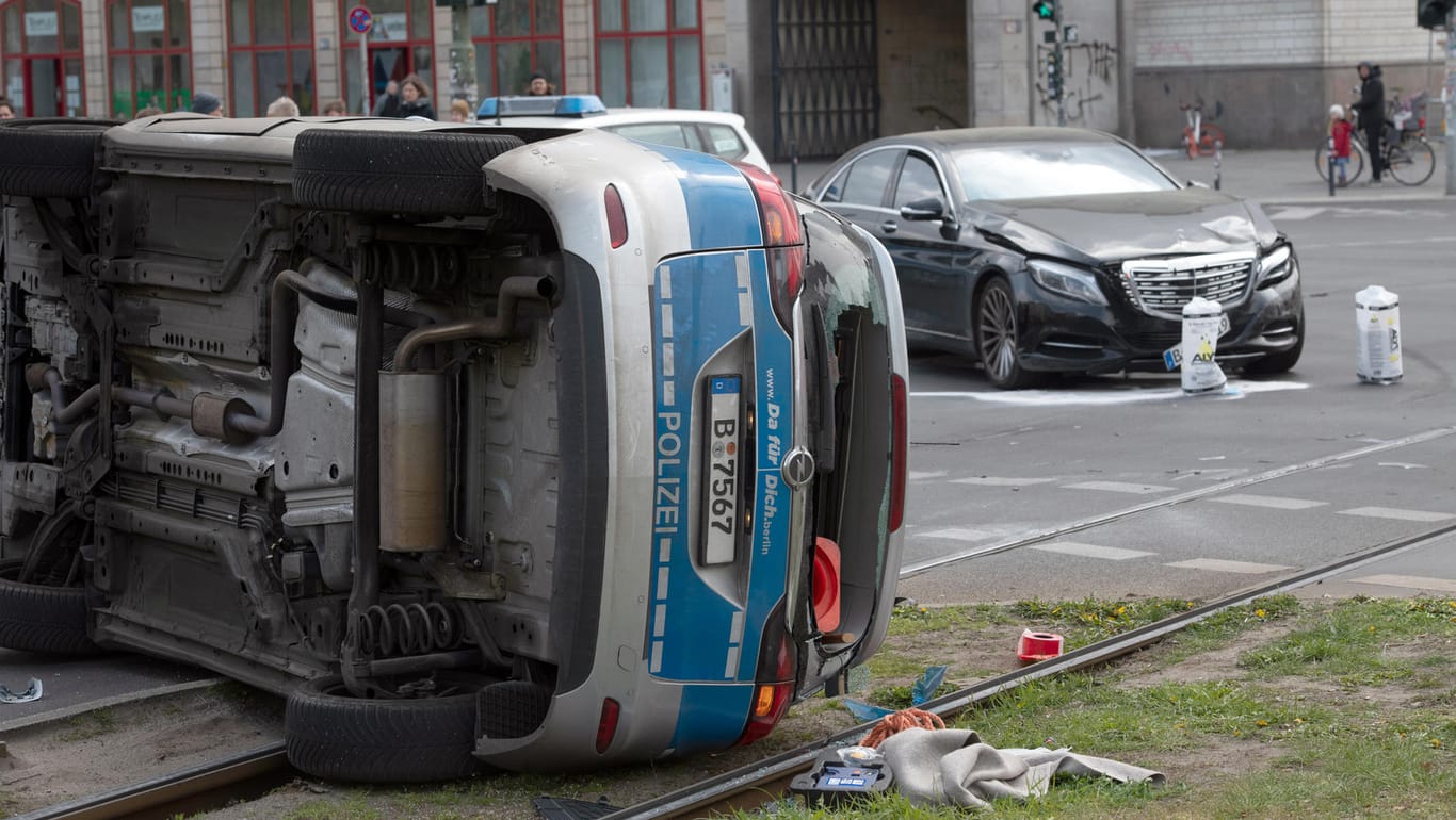 Ein umgekippter Streifenwagen liegt nach einem Zusammenstoß mit einem Mercedes auf einem Grünstreifen am Frankfurter Tor.