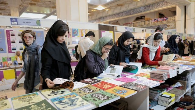 Frauen mit Kopftuch besuchen eine Buchmesse in Teheran. Frauen mit Kopftuch besuchen eine Buchmesse in Teheran.