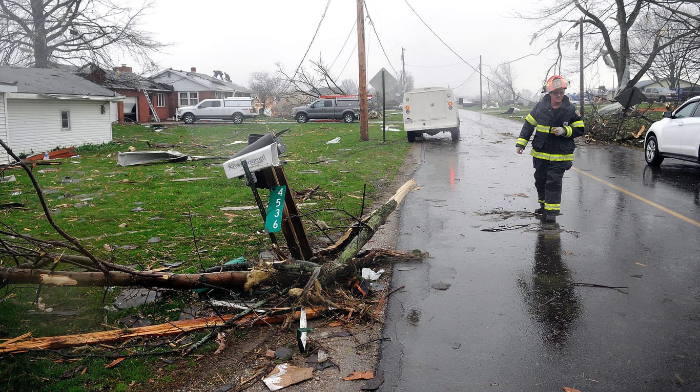 Shelby: Ein Feuerwehrmann geht nach schweren Unwettern eine Straße entlang. Eine massive Sturmfront hat auf ihrem Weg durch den Süden der USA eine Schneise von Tod und Verwüstung hinterlassen.