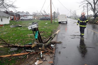 Shelby: Ein Feuerwehrmann geht nach schweren Unwettern eine Straße entlang. Eine massive Sturmfront hat auf ihrem Weg durch den Süden der USA eine Schneise von Tod und Verwüstung hinterlassen.