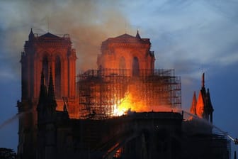 Ein Feuerwehrmann (r) versucht, das Feuer in der Kathedrale Notre-Dame zu löschen.