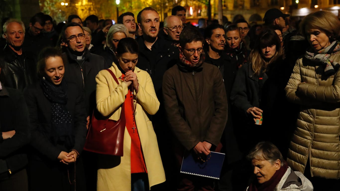 Die Bevölkerung in Paris schaut geschockt auf den Brand der Kathedrale Note-Dame.