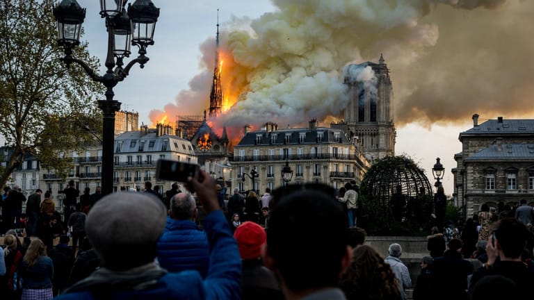 Bürger in Paris beobachten die brennende Kathedrale.