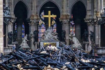Trümmerteile und verkohlte Holzbalken liegen im Inneren der Kathedrale Notre-Dame.