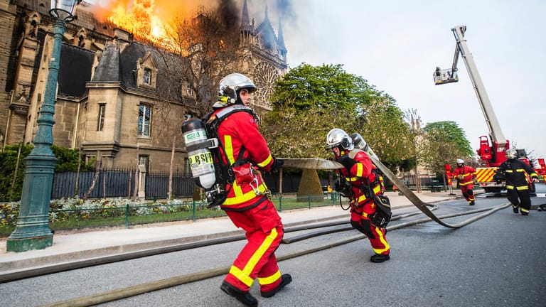 Feuerwehrleute laufen zum Einsatz: Hunderte Rettungskräfte haben den Brand der Notre-Dame eingedämmt.