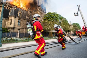 Feuerwehrleute laufen zum Einsatz: Hunderte Rettungskräfte haben den Brand der Notre-Dame eingedämmt.