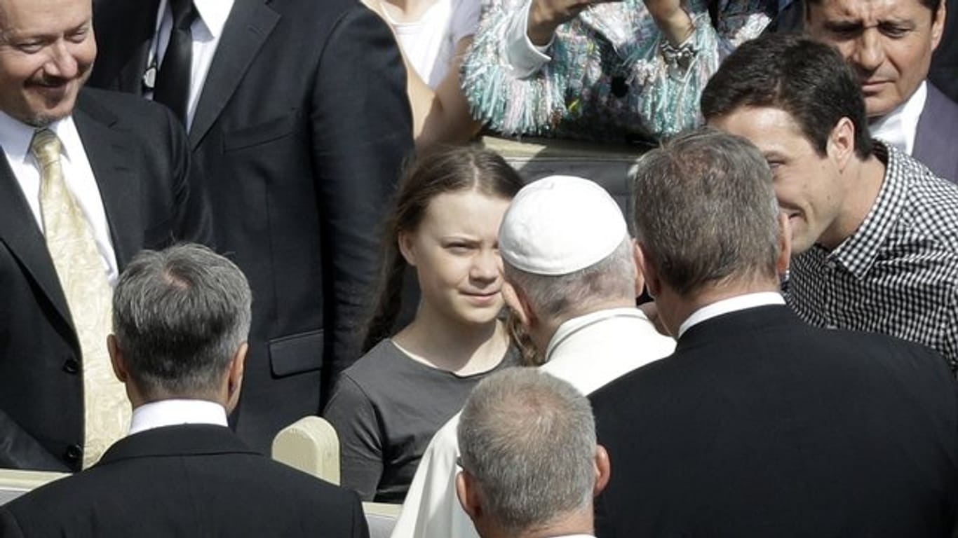 Papst Franziskus begrüßt die schwedische Klimaaktivistin Greta Thunberg (M) während seiner wöchentlichen Generalaudienz auf dem Petersplatz im Vatikan.