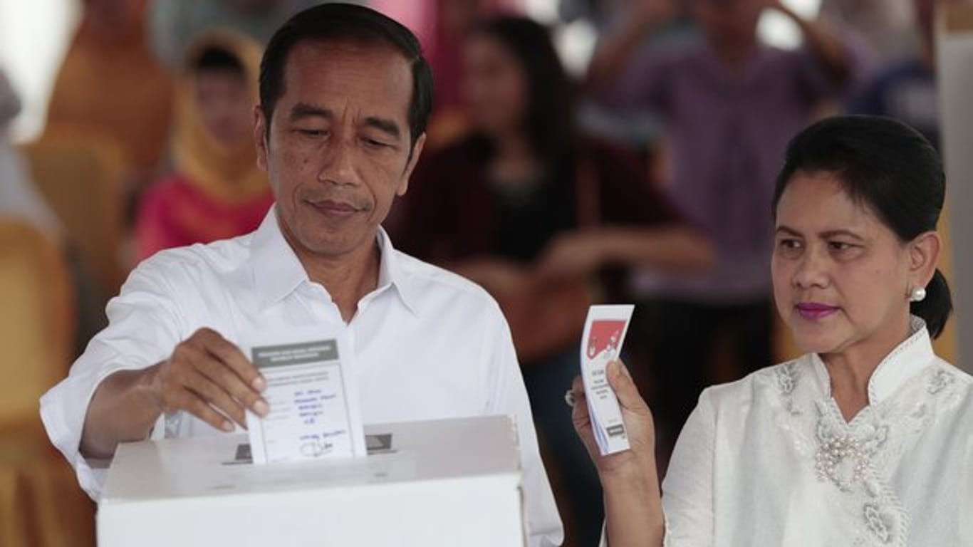 Joko Widodo, Präsident von Indonesien, und seine Frau Iriana geben in einem Wahllokal in Jakarta ihre Stimme ab.