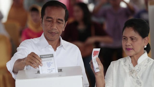 Joko Widodo, Präsident von Indonesien, und seine Frau Iriana geben in einem Wahllokal in Jakarta ihre Stimme ab.