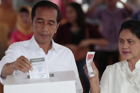 Joko Widodo, Präsident von Indonesien, und seine Frau Iriana geben in einem Wahllokal in Jakarta ihre Stimme ab.