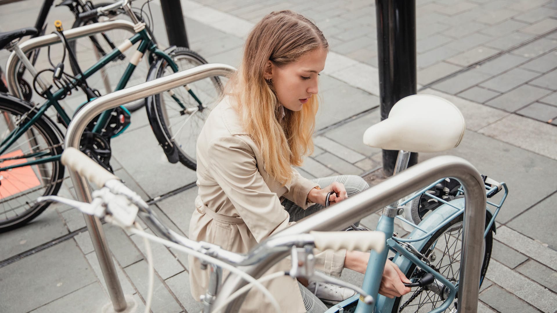 Frau schließt Fahrrad ab: Experten raten, Räder möglichst immer doppelt mit unterschiedlichen Schlosssystemen abzusichern.